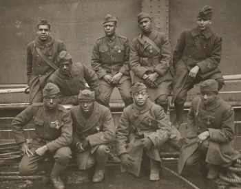 Historical photo of nine African American men in U.S. military uniforms.